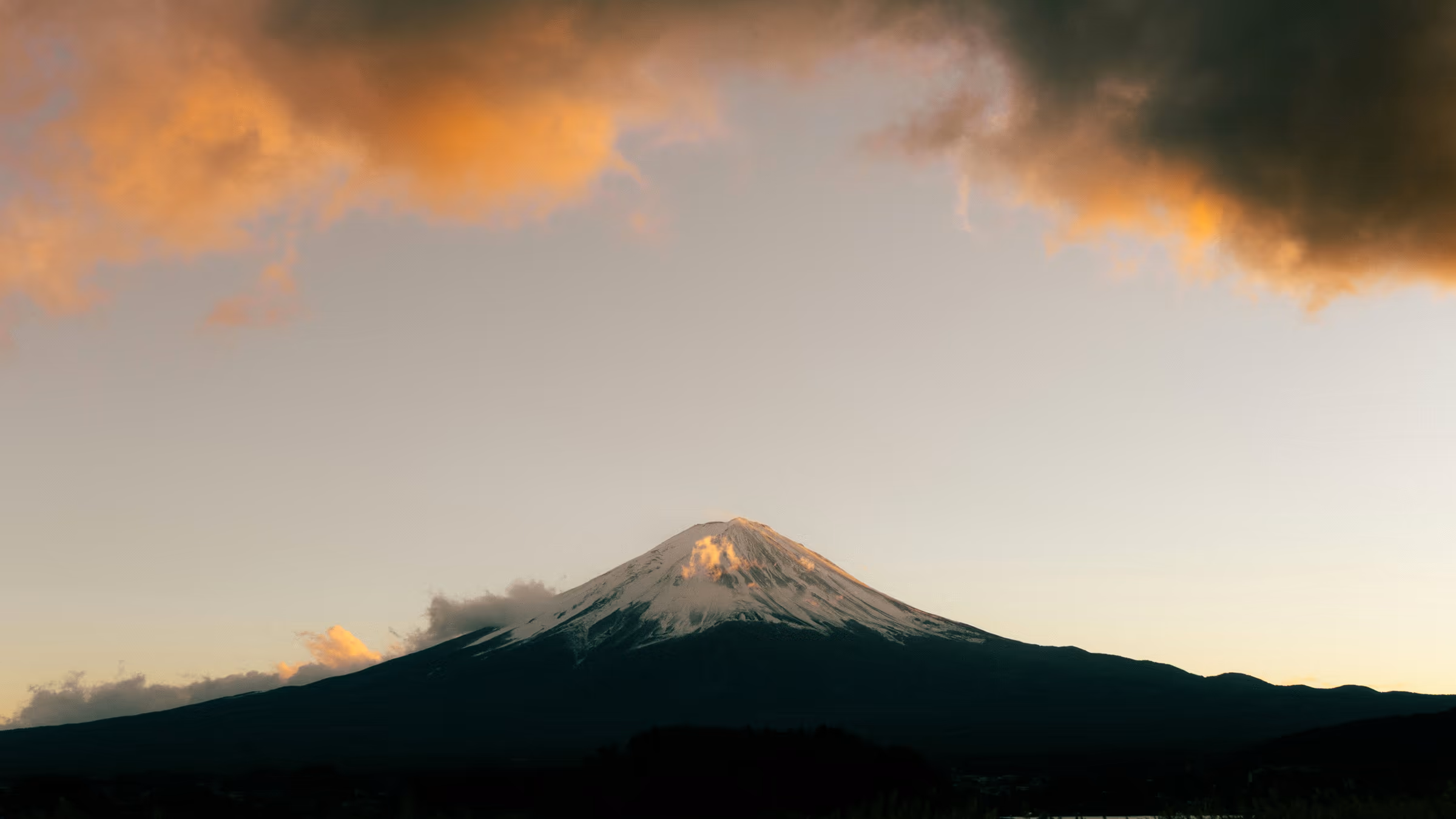 Snow-capped Mount Fuji at sunrise with vibrant clouds